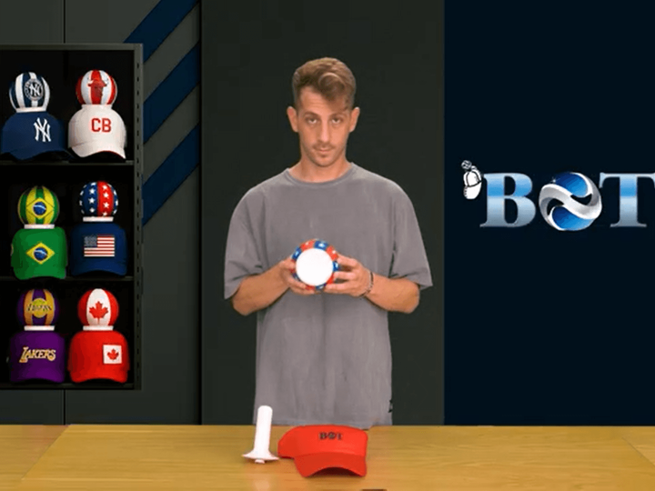 Alien wearing an SL Benfica LED cap surrounded and hugged by fans